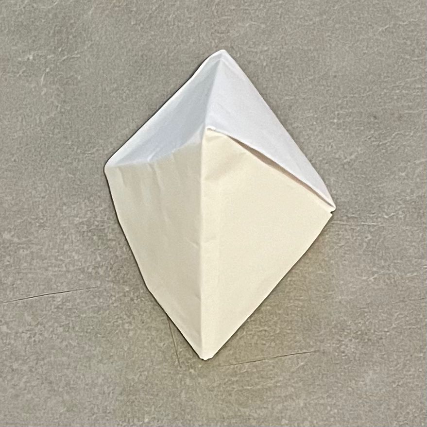 The photo of a pyramid folded with paper. It was taken from above.