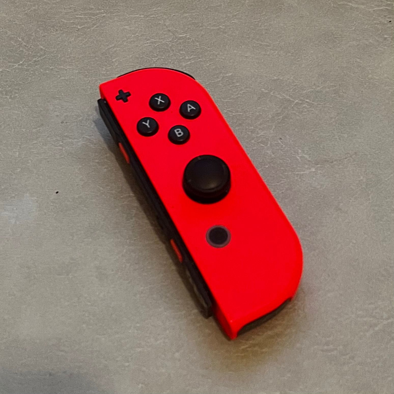 The photo of a switch controller. Taken from the front view. There are several buttons and extrusions on the surface. Consider as complex geometry object.
